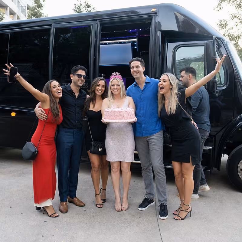 Group boarding a white charter bus for Birthday Transportation transportation in Peoria